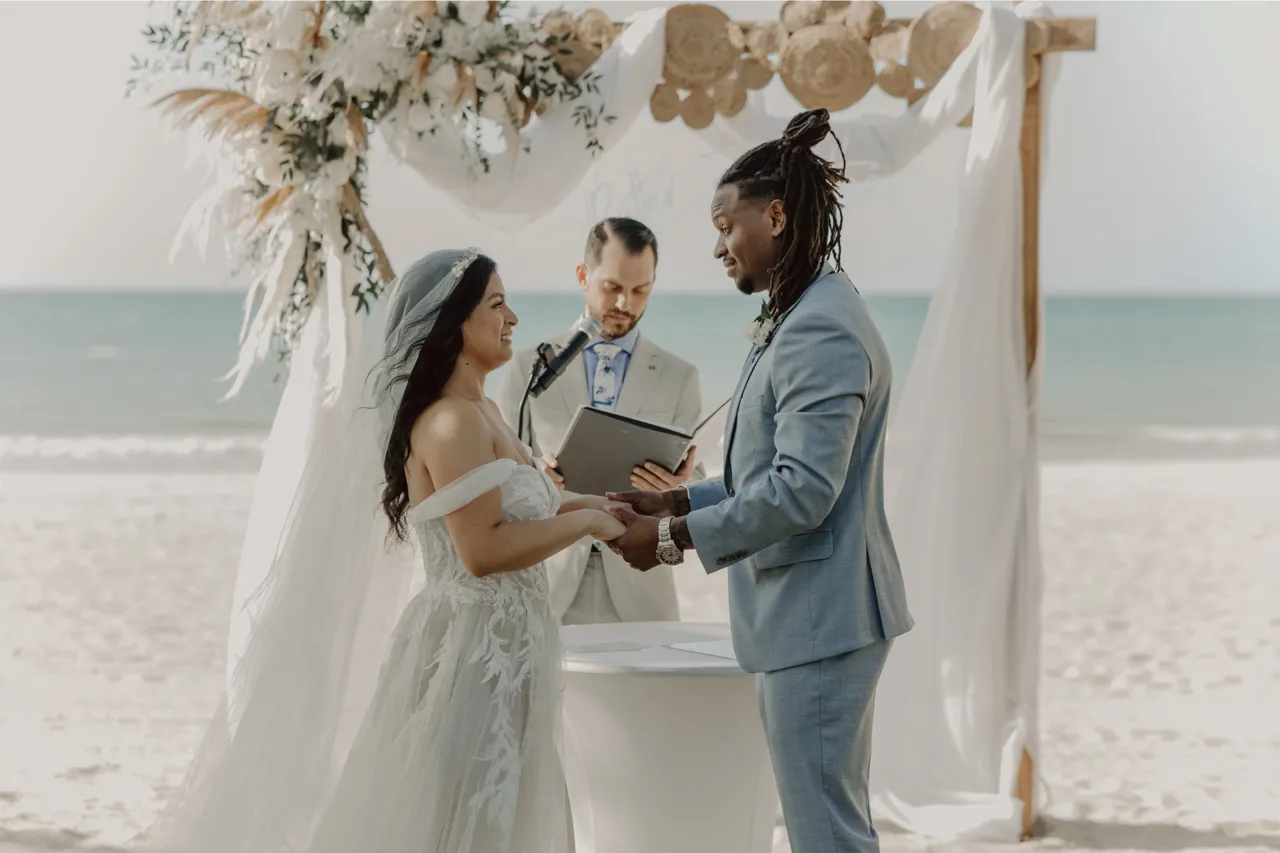 A couple exchanging vows at a beach ceremony